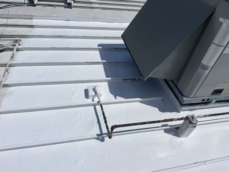 The treated metal-panel area beside a rooftop equipment base after localized repairs.