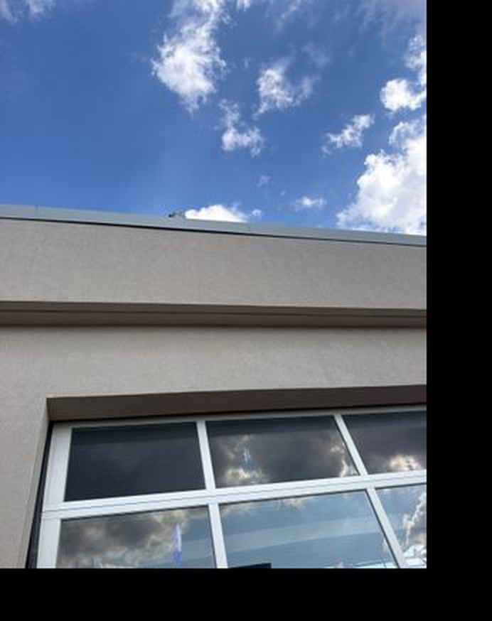Exterior wall and roofline at a Columbus-area indoor entertainment venue during a water-intrusion assessment.