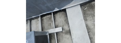 Metal roof transition beside an equipment curb at a convenience store building.