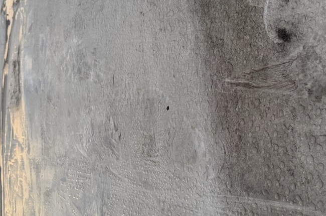 Weathered low-slope roof membrane at a Monroe-area travel center during a leak investigation.