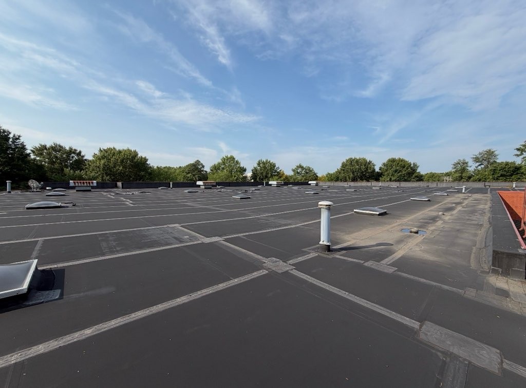 The vacant warehouse's low-slope roof, with perimeter flashing, curbs and penetrations.