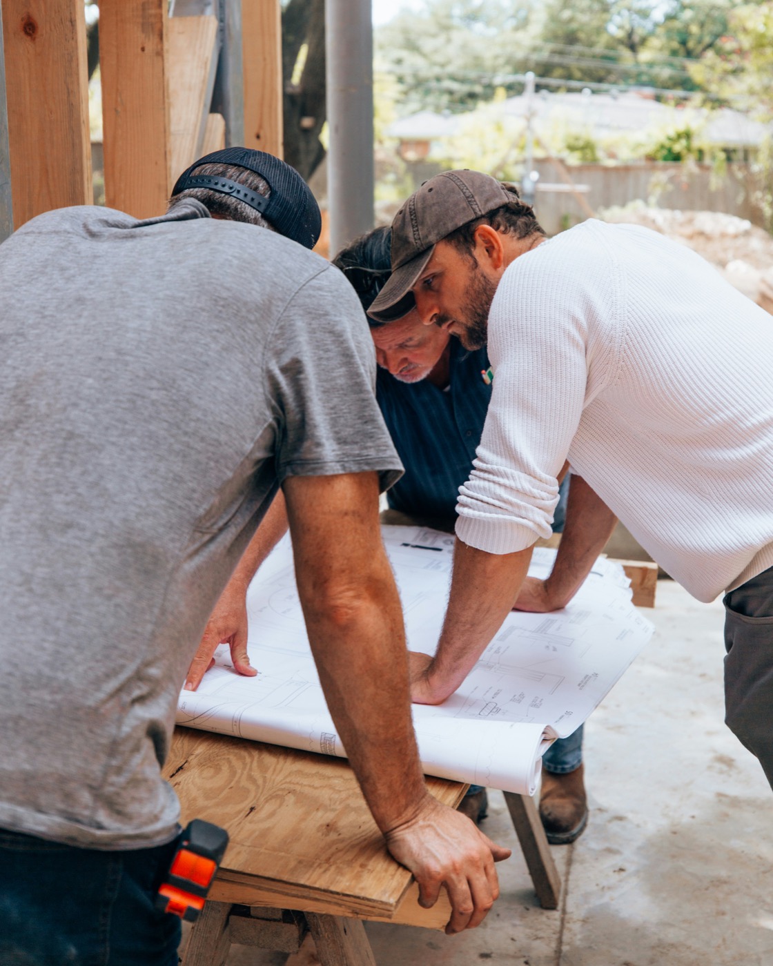 Three people reviewing building plans together